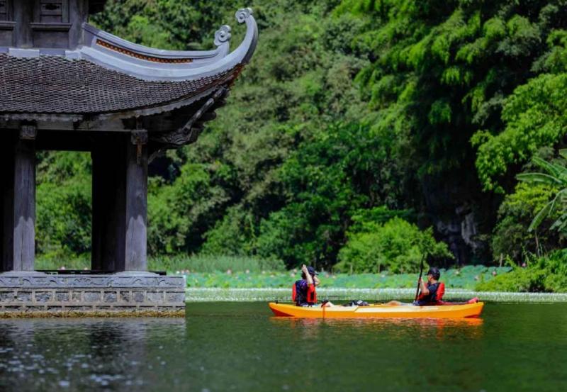 Du khách đang thích thú chèo thuyền Kayak trên dòng sông tại khu du lịch Tre Việt, tận hưởng không khí trong lành.